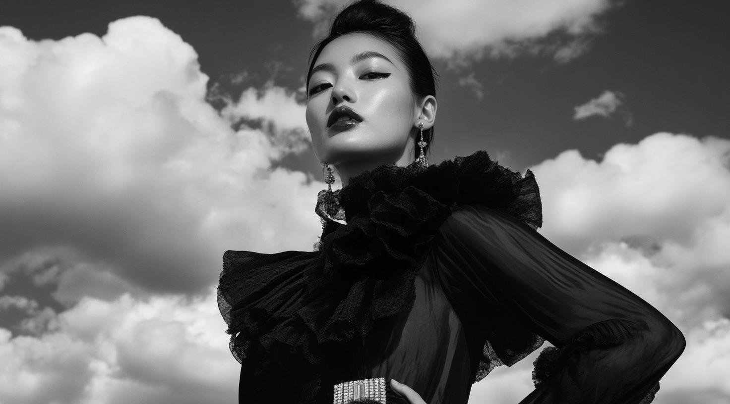 Black sculptural fashion silhouette against a bright blue sky